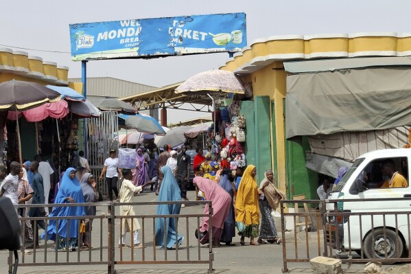 People walk past the main market in Maiduguri, Nigeria, Saturday, March 15, 2025. (AP Photo/Joshua Olatunji)
